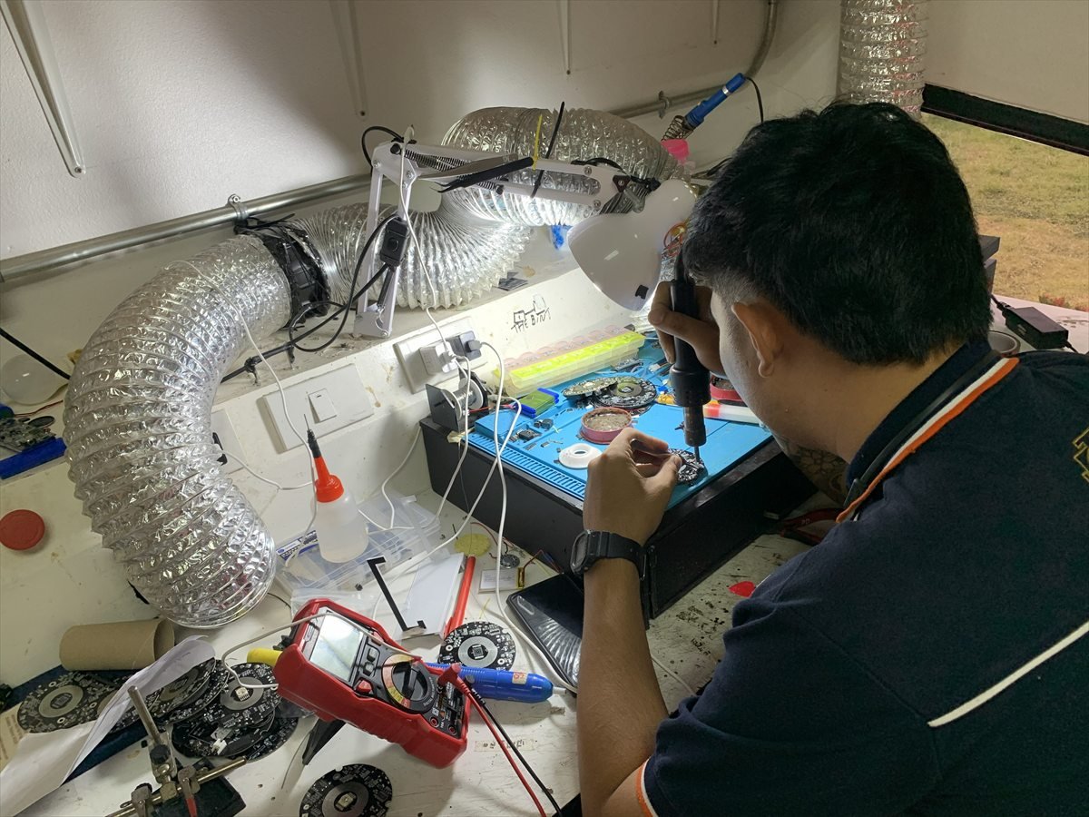 Light Mandalas team member assembling circuit components at a workbench